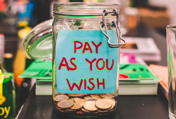 aneta-pawlik-1074542-unsplash Jar with coins that says "Pay as you wish" on the front.