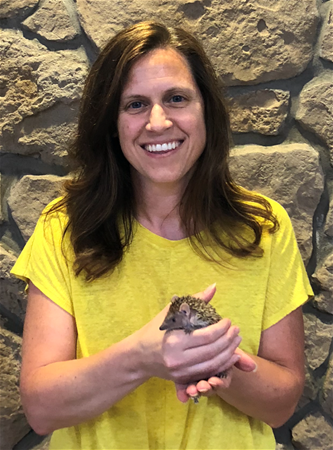 Mellissa Reed Women smiling and holding a hedgehog.