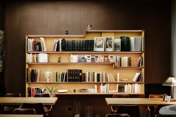 samuel-zeller-106867-unsplash Room with desk and wide bookshelf along the back wall.