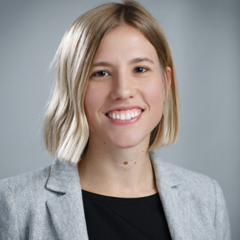Woman professionally dressed and smiling for camera.