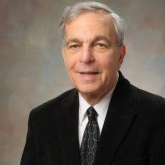 Man in suit smiling for camera.