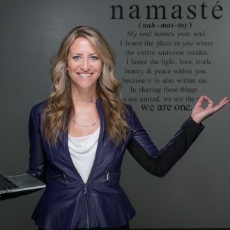 Woman holding laptop and doing yoga pose.