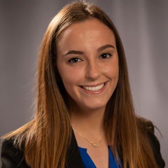 Professionally dressed woman smiling for camera.