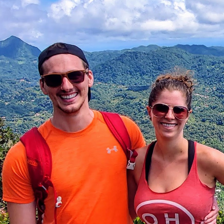 Man and woman smiling for camera with arms around each other.
