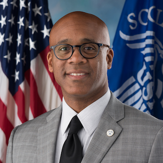 Man wearing suit and smiling for camera.