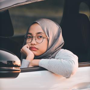 ilmi-amali-q-a-0JZMQ0KqGCc-unsplash Woman resting on open window in car.