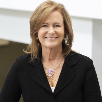 Professionally dressed woman smiling for camera.