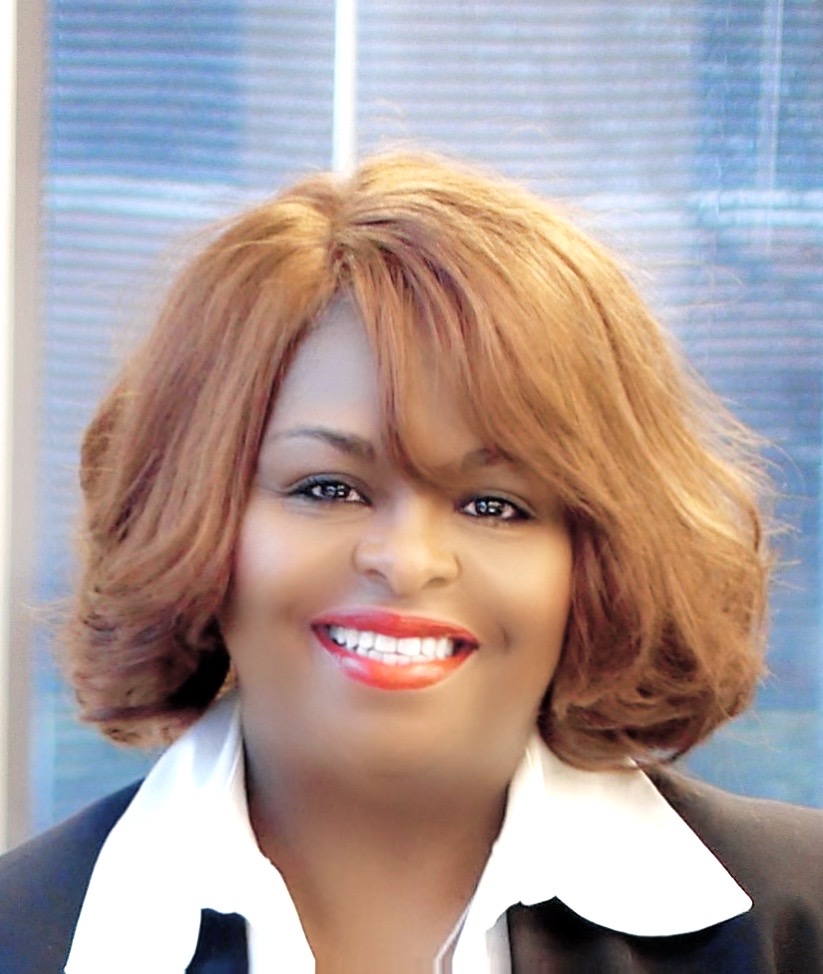 Woman dressed professionally and smiling for the camera.