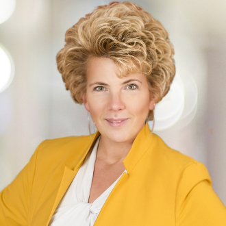 Woman in suit smiling for camera.