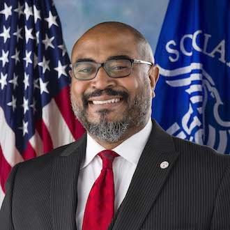 Man wearing suit and smiling for camera.