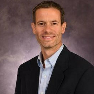 Man wearing suit and smiling for camera.