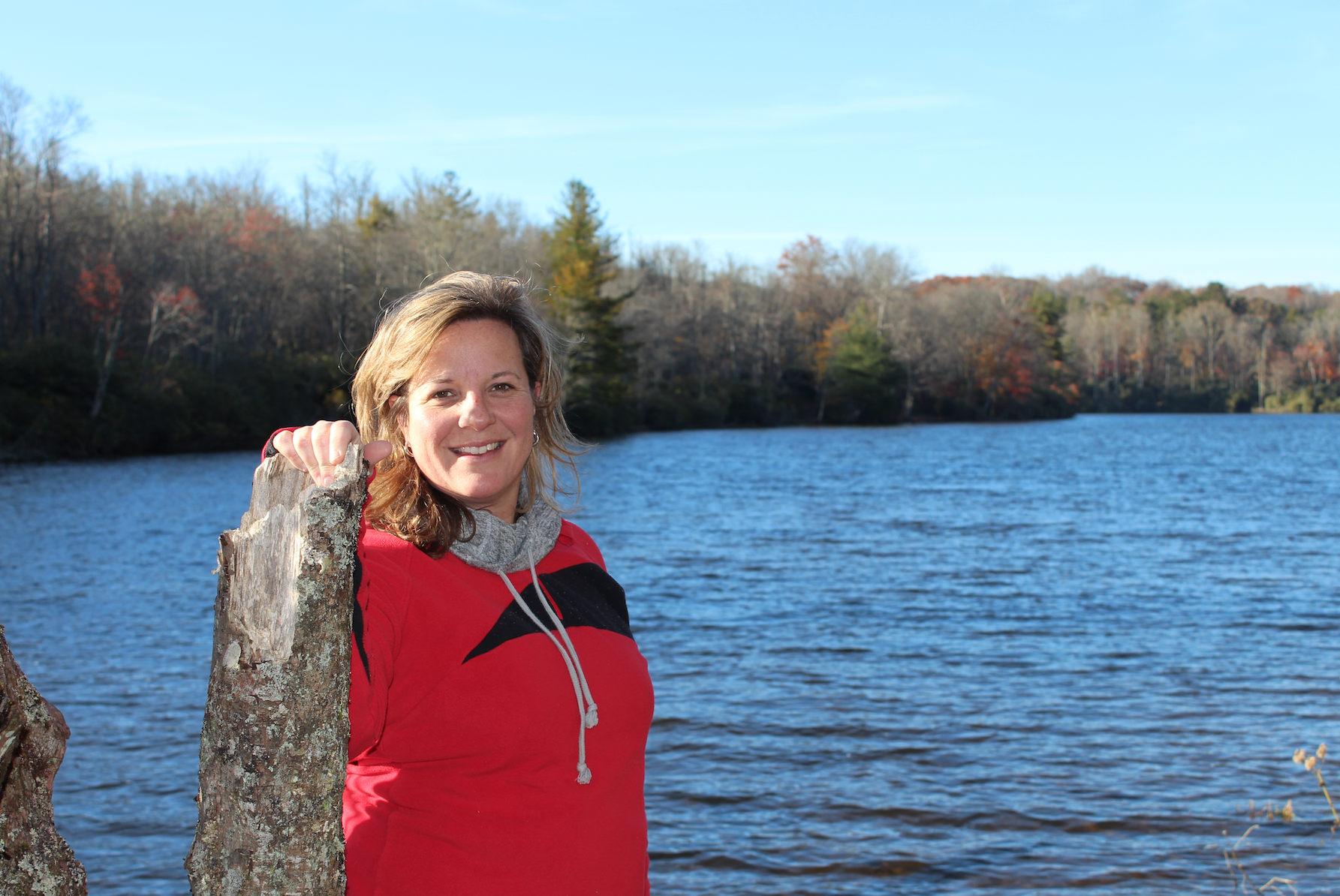 Woman smiling with lake behind her.
